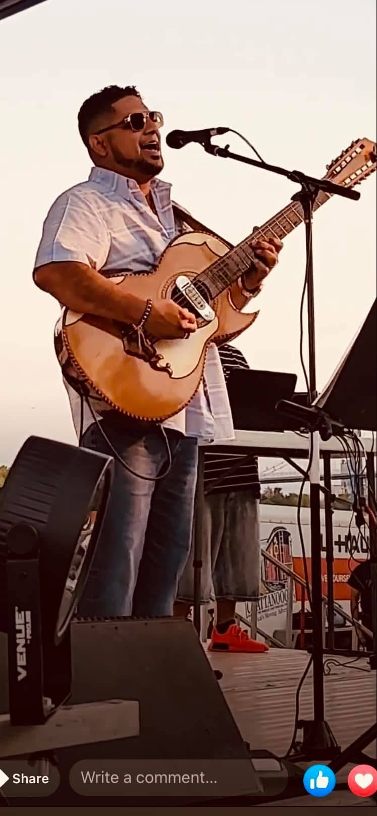 Augustine Moya playing guitar and singing